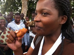 Woman enjoying some of a new recipe shared at field day, using crops encouraged through MAFFA. Really, it was good!